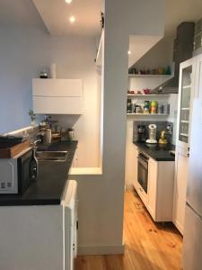 a kitchen with white cabinets and black countertops at Appartement à côté de la Gare in Hendaye +5 photos