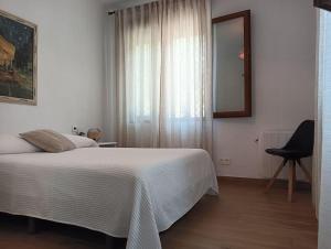 a bedroom with a bed and a chair and a window at La casita de la Alquería, Montanejos in Montanejos