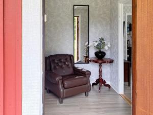 einen braunen Ledersessel in einem Zimmer mit Spiegel in der Unterkunft Holiday home LJUNG in Ljung