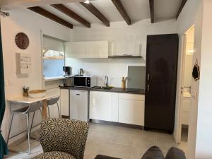 a kitchen with white cabinets and a black refrigerator at BE BLUE GREEN in Fort-de-France