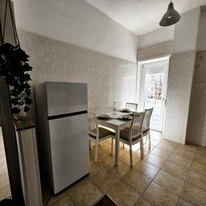 MareSole Apartment في ليدو دي أوستيا: مطبخ مع ثلاجة وطاولة وكراسي