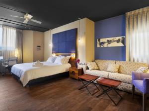 特拉维夫PLAY Seaport Suite Hotel TLV的配有床和沙发的酒店房间 更多37张照片