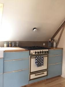 een keuken met een fornuis en een aantal laden bij Gîte la Luchette - petit village médiéval de la Somme in Lucheux