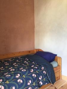 een kleine slaapkamer met een bed met een bloemenbed bij Gîte la Luchette - petit village médiéval de la Somme in Lucheux