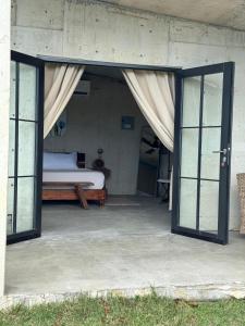 a bedroom with a bed and sliding glass doors at The Serene House Bed & Breakfast in Luquillo