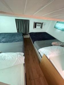 two beds in a small room on a boat at Updated houseboat on the river! in Fort Lauderdale