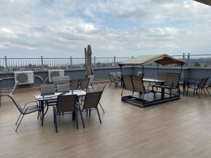 a patio with tables and chairs on a roof at Neema Executive Suites Near Junction Mall With Balcony in Nairobi