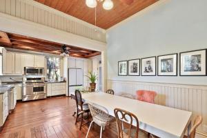 uma cozinha com uma mesa branca e cadeiras em 905 Seaside - Designer, Historic, Cold Plunge Pool, Pet-Friendly and King Beds em Brunswick