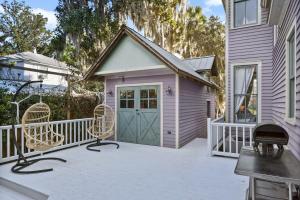 a small pink house with a porch with chairs at 905 Seaside - Designer, Historic, Cold Plunge Pool, Pet-Friendly and King Beds in Brunswick