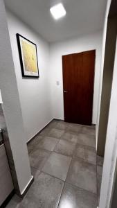 Habitación vacía con puerta y suelo de baldosa en Apartamentos Mamma Mia, en Córdoba