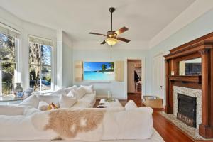 uma sala de estar com mobiliário branco e uma lareira em 905 Seaside - Designer, Historic, Cold Plunge Pool, Pet-Friendly and King Beds em Brunswick