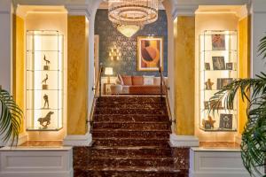 a staircase in a living room with a chandelier at Grand Hotel Casselbergh in Bruges