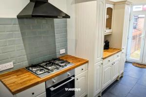 uma cozinha com um fogão e uma bancada em Crawford House - Stunning 2 Bedroom House in Manchester em Manchester