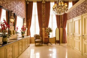 a dressing room with a chandelier and a chair and a window at Grand Hotel Casselbergh in Bruges