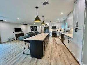 a large kitchen and living room with a large island at Love Shack in Foley/ Hot Tub / Modern Cozy in Foley