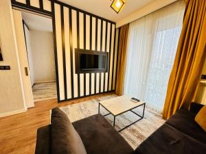 ein Wohnzimmer mit einem Sofa und einem TV in der Unterkunft LUX DECORATED APARTMENT in Istanbul
