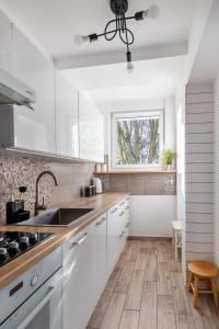 a kitchen with white cabinets and a sink and a window at GA- One Bedroom Apartment -Old Town - Anielewicza in Warsaw