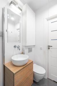 La salle de bains blanche est pourvue d'un lavabo et de toilettes. dans l'établissement GA- One Bedroom Apartment -Old Town - Anielewicza, à Varsovie