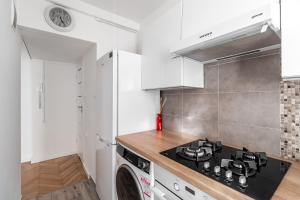 a kitchen with a stove top oven next to a washing machine at GA- One Bedroom Apartment -Old Town - Anielewicza in Warsaw