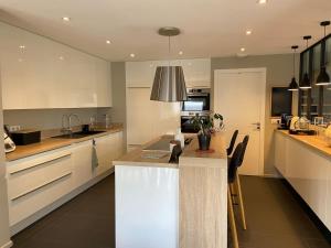 a kitchen with white cabinets and a island in it at Embruns et Sarrasin in Combrit