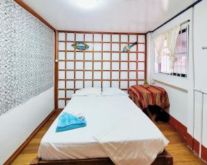 um pequeno quarto com uma cama e uma janela em Hogar Marujita em Iquitos