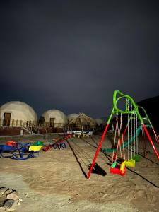 um grupo de equipamentos de brincar numa praia com cúpulas em Adel rum camp bubbles em Wadi Rum