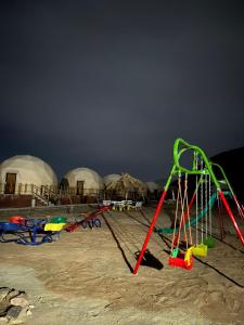 a group of play equipment on a beach with domes at Adel rum camp bubbles in Wadi Rum