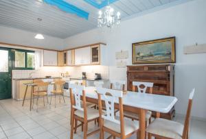 een keuken en eetkamer met een tafel en stoelen bij Villa Voula in Ágios Nikólaos