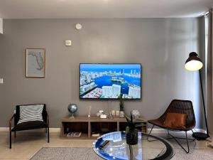 uma sala de estar com uma mesa e uma televisão na parede em Lovely Midblock building 1 bedroom 1 bathroom apartment em Miami