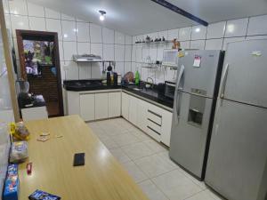 een keuken met een houten tafel en een koelkast bij Sítio da Fabi in Brumadinho