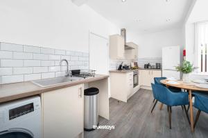 a kitchen with a sink and a table with blue chairs at NEW Stanley House - Stunning 2 Bedroom House in Etruria
