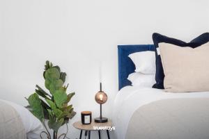Un dormitorio con una cama y una mesa con una planta en NEW Stanley House - Stunning 2 Bedroom House en Etruria