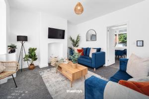 a living room with a blue couch and a table at NEW Stanley House - Stunning 2 Bedroom House in Etruria