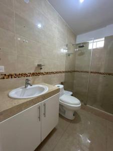 y baño con aseo, lavabo y ducha. en Apartamento familiar de lujo (402), en San Bartolo