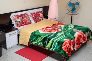a bedroom with a bed with a green and red blanket at Moments Lodge in Lilongwe
