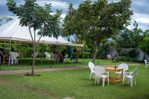 a table and chairs in a park with a tent at Moments Lodge in Lilongwe