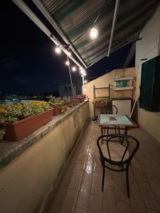 ローマにあるSan Lorenzo Apartmentの- パティオ(夜間のバルコニーにテーブルと椅子付)