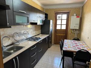 eine Küche mit einer Spüle und einem Tisch mit einer Arbeitsplatte in der Unterkunft Zuzumbo's shine in Telawi