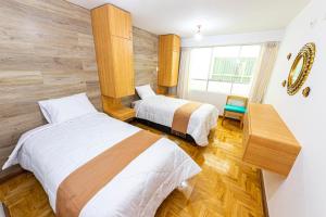 a hotel room with two beds and a window at INYAWASI APARTMENT in Cusco +60 photos