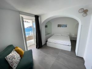 a bedroom with a bed and a couch and a window at Amalfi Saracena House in Amalfi