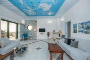 een woonkamer met een blauw plafond bij Villa Voula in Ágios Nikólaos