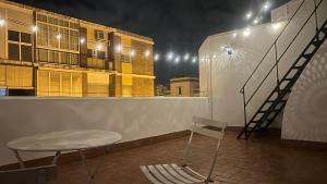 una silla y una mesa en un balcón por la noche en Selecta Casa junto a Triana, en Sevilla