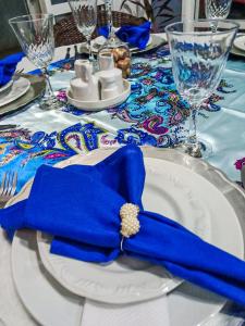 Pousada La Casona في تيباجي: منديل أزرق على صحن أبيض على طاولة