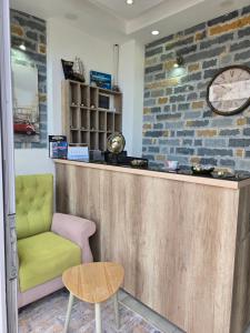 a bar with a green chair and a clock at Apartments Mediteran in Ulcinj