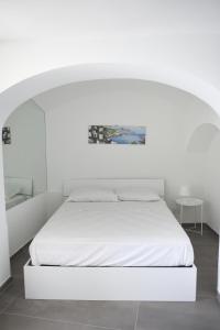 アマルフィにあるAmalfi Saracena Houseの白いベッドルーム(アーチ型の白いベッド付)