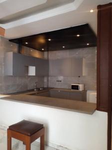 a kitchen with a counter with a sink and a microwave at Apparemment meublé au bord de la mer in Guediawaye