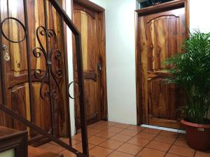 a hallway with a wooden door and a potted plant at MI CASITA VERDE in Baños