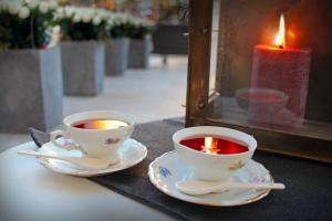 deux tasses de thé et une bougie sur une table dans l'établissement [La Casa DiLù] Moderno Trilocale e Ampio Terrazzo, à Grugliasco