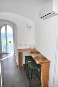 アマルフィにあるAmalfi Saracena Houseのテーブルとスツールが備わる海の景色を望む客室です。