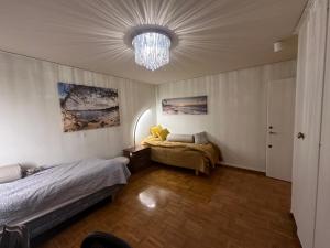 1 dormitorio con 2 camas y lámpara de araña en Stockholm stort Rum - Dator Arbetsplats Gratis Wifi 1Gb Fiber Parkering Garderober Room2, en Täby